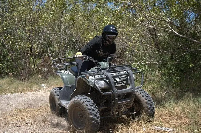 Persona en ATV recorriendo un sendero de arena en la selva